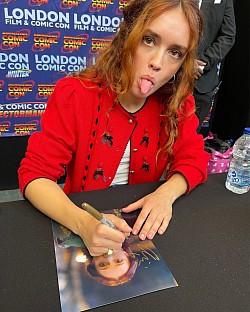 Olivia Cooke while autographing her photo